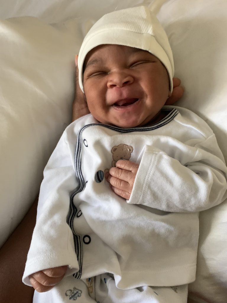 newborn baby smiling in his sleep shortly after birth